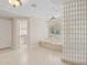 Bright bathroom featuring a glass block partition wall, soaking tub, neutral color palette, and walk-in closet at 8815 N 65Th St, Paradise Valley, AZ 85253
