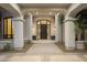 Close-up view of the grand entrance featuring an arched portico, detailed door, and elegant lighting fixtures at 8815 N 65Th St, Paradise Valley, AZ 85253