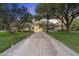 Gorgeous house exterior with a long drive, manicured lawn, mature trees, and a grand entrance at 8815 N 65Th St, Paradise Valley, AZ 85253