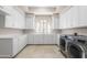Well-lit laundry room with ample cabinet space and counter space, plus front loading washer/dryer at 8815 N 65Th St, Paradise Valley, AZ 85253