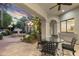 Covered patio features a ceiling fan, dining area and views of the landscaped backyard and fountain at 8815 N 65Th St, Paradise Valley, AZ 85253
