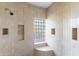 Walk-in shower features a glass block window, built-in niches, and neutral tile surround at 8815 N 65Th St, Paradise Valley, AZ 85253