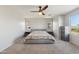 Bright bedroom with a ceiling fan, natural light from large windows, and matching gray bedside tables at 894 S Buena Vista Dr, Apache Junction, AZ 85120