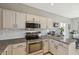 Well-lit kitchen with stainless steel appliances, white cabinets, and granite countertops with eat in bar area at 894 S Buena Vista Dr, Apache Junction, AZ 85120
