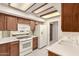 Kitchen featuring tile floors, wood cabinets, and white appliances at 9120 W Wescott Dr, Peoria, AZ 85382