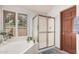 Bathroom featuring a glass enclosed shower, soaking tub, and view from the window at 9414 S La Rosa Dr, Tempe, AZ 85284