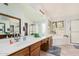 Bright bathroom featuring a double vanity, large mirror, soaking tub, and glass-enclosed shower at 9414 S La Rosa Dr, Tempe, AZ 85284