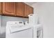 Laundry room featuring white washer and dryer with cabinets above at 9414 S La Rosa Dr, Tempe, AZ 85284