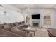 Inviting living room featuring a comfortable sectional sofa, fireplace, and bright natural light at 9414 S La Rosa Dr, Tempe, AZ 85284
