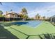 Well-lit tennis court next to residential buildings, surrounded by mature trees, offering a great recreational space at 9450 E Becker Ln # 1071, Scottsdale, AZ 85260