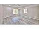 Bright bedroom featuring light gray wood floors, a ceiling fan, and natural light from two windows at 9551 E Redfield Rd # 1061, Scottsdale, AZ 85260