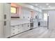 Modern kitchen with white cabinets, stainless steel appliances, and beautiful gray wood-look flooring at 9551 E Redfield Rd # 1061, Scottsdale, AZ 85260