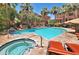 Community pool with jacuzzi, palm trees, ample seating, and beautiful landscaping for residents at 9551 E Redfield Rd # 1061, Scottsdale, AZ 85260