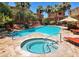 Community pool with hot tub, lounge chairs, sun umbrella and palm trees for residents enjoyment at 9551 E Redfield Rd # 1061, Scottsdale, AZ 85260