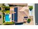 Aerial view of a tiled roof with solar panels next to a sparkling pool and landscaped backyard oasis at 9677 W Patrick Ln, Peoria, AZ 85383
