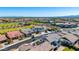 Expansive aerial view of a neighborhood showcasing homes, streets, and common green spaces with mountain views at 9677 W Patrick Ln, Peoria, AZ 85383