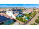Inviting backyard featuring a sparkling pool, lush landscaping, and solar panels on the roof at 9677 W Patrick Ln, Peoria, AZ 85383