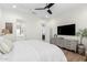 Bright bedroom features a ceiling fan, neutral decor, and a private ensuite bathroom at 9677 W Patrick Ln, Peoria, AZ 85383