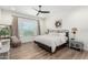 A bright bedroom features wood floors, a ceiling fan, and a window with views at 9677 W Patrick Ln, Peoria, AZ 85383