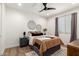 A cozy bedroom features wood floors, a ceiling fan, and a patterned blanket at 9677 W Patrick Ln, Peoria, AZ 85383
