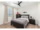 A bedroom features wood floors, a ceiling fan, and neutral toned decor at 9677 W Patrick Ln, Peoria, AZ 85383