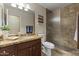 Bathroom featuring a granite countertop vanity with a sink, toilet, and a tiled walk-in shower at 10747 W Via Del Sol --, Peoria, AZ 85373