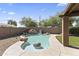 Backyard pool and rock waterfall feature with lush landscaping on a sunny day at 10747 W Via Del Sol --, Peoria, AZ 85373