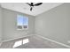 This bedroom has gray walls, a ceiling fan, concrete floors, and a window view of the desert and mountains at 11798 S 216Th Ave, Buckeye, AZ 85326