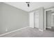 This bedroom has gray walls, white trim and baseboards, a ceiling fan, closet, and concrete floors at 11798 S 216Th Ave, Buckeye, AZ 85326