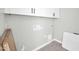 This laundry room has overhead cabinets, hookups, and tiled floors at 11798 S 216Th Ave, Buckeye, AZ 85326