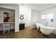 Bathroom with terra cotta tile flooring, free-standing tub, and adjacent vanity space with a chair at 1249 E Desert Park Ln, Phoenix, AZ 85020