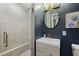 Stylish bathroom featuring a glass shower, modern vanity with a round mirror and a muted blue wall at 1249 E Desert Park Ln, Phoenix, AZ 85020