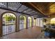 Exterior courtyard featuring brick floors, arched doorways, and black metal gates at 1249 E Desert Park Ln, Phoenix, AZ 85020