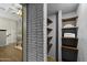 Hallway featuring built-in shelving, brick accents, and tile flooring throughout at 1249 E Desert Park Ln, Phoenix, AZ 85020