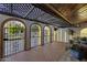 Covered patio with arched entryways, wrought iron gates, brick flooring, and ample light at 1249 E Desert Park Ln, Phoenix, AZ 85020