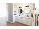 Bright bathroom featuring double sinks, round mirrors, white cabinets, and built-in shelves at 1330 E Monte Vista Rd, Phoenix, AZ 85006