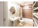 Bathroom with neutral-toned tile, tub, open shelving, and pedestal sink at 1330 E Monte Vista Rd, Phoenix, AZ 85006