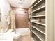 Bathroom with neutral-toned tile, tub, open shelving, and pedestal sink at 1330 E Monte Vista Rd, Phoenix, AZ 85006