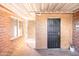 Enclosed outdoor space featuring a brick wall, protective door, and ample sunlight at 1330 E Monte Vista Rd, Phoenix, AZ 85006