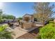 Outdoor kitchen with stainless steel grill, a fire pit, and seating in the landscaped backyard at 13583 S 177Th Ln, Goodyear, AZ 85338