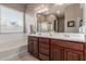 This bathroom features dual sinks, wood cabinets, and a separate tub and shower at 13583 S 177Th Ln, Goodyear, AZ 85338
