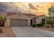 Exterior shot of a one-story home featuring a three car garage and desert landscaping at 13583 S 177Th Ln, Goodyear, AZ 85338