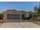 Exterior shot of a one-story home featuring a three car garage and desert landscaping at 13583 S 177Th Ln, Goodyear, AZ 85338