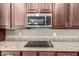 This kitchen features granite countertops and a stainless steel microwave above the stovetop at 13583 S 177Th Ln, Goodyear, AZ 85338