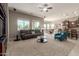 Open-concept living room with plush seating, ceiling fan, and abundant natural light at 13583 S 177Th Ln, Goodyear, AZ 85338