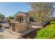 Outdoor kitchen with a built-in grill, bar seating, and a view of the backyard amenities at 13583 S 177Th Ln, Goodyear, AZ 85338