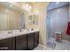 Bathroom with dual sinks, a large mirror, and a glass-enclosed shower at 1367 S Country Club Dr # 1127, Mesa, AZ 85210