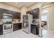 Modern kitchen with dark cabinets, stainless steel appliances, and tiled flooring at 1367 S Country Club Dr # 1127, Mesa, AZ 85210