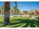 A spacious community pool surrounded by green grass and palm trees, creating a resort-like atmosphere at 1367 S Country Club Dr # 1127, Mesa, AZ 85210