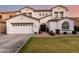 Charming two-story home featuring a well-maintained lawn, arched entryway, and a three-car garage at 1429 E Lowell Ave, Gilbert, AZ 85295
